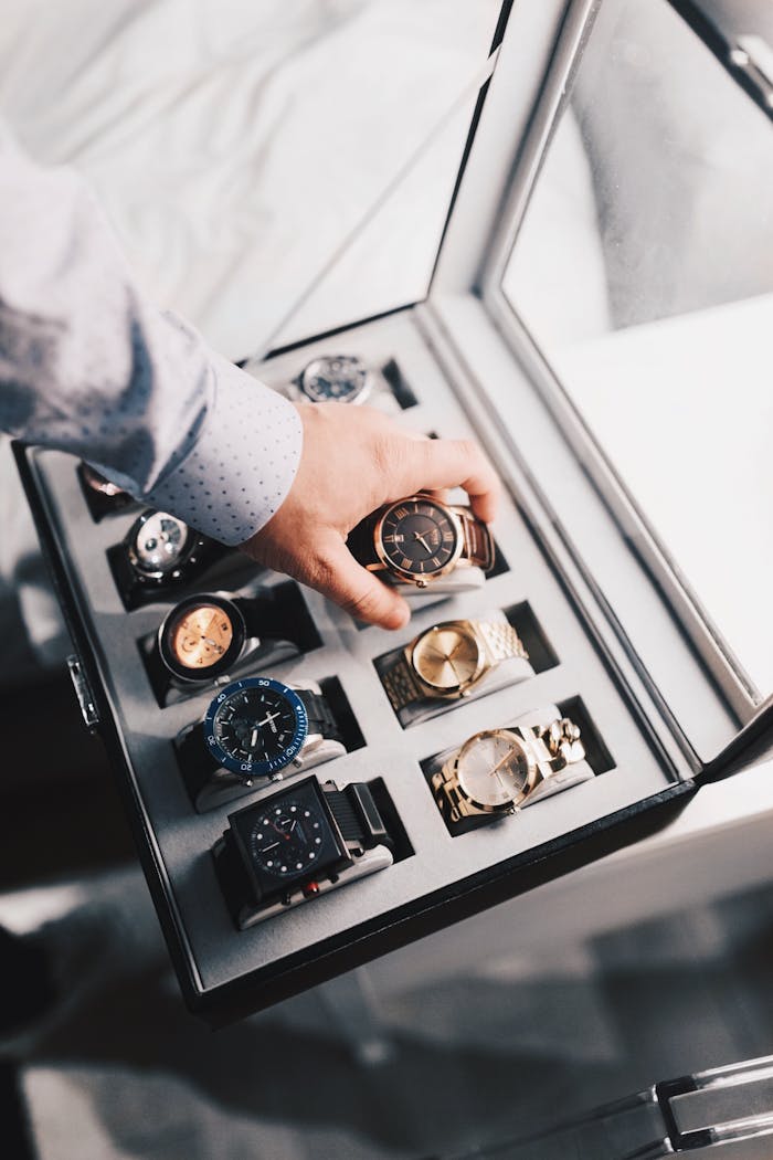 hero-gallery-04 A sophisticated display of luxury watches in an elegant case with a hand selecting one.
